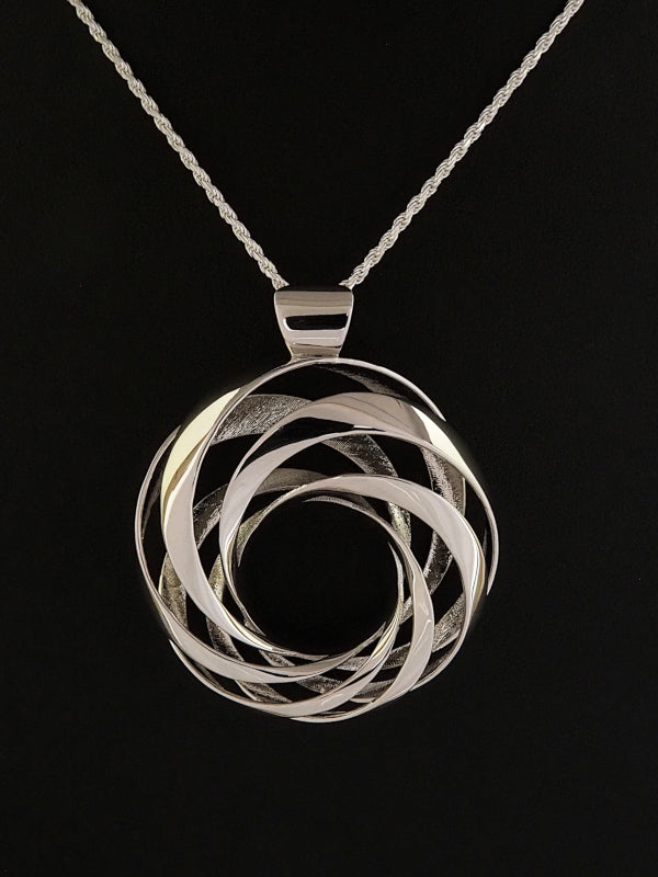 A 35mm rhodium-plated brass cyclide pendant on a silver French rope chain.