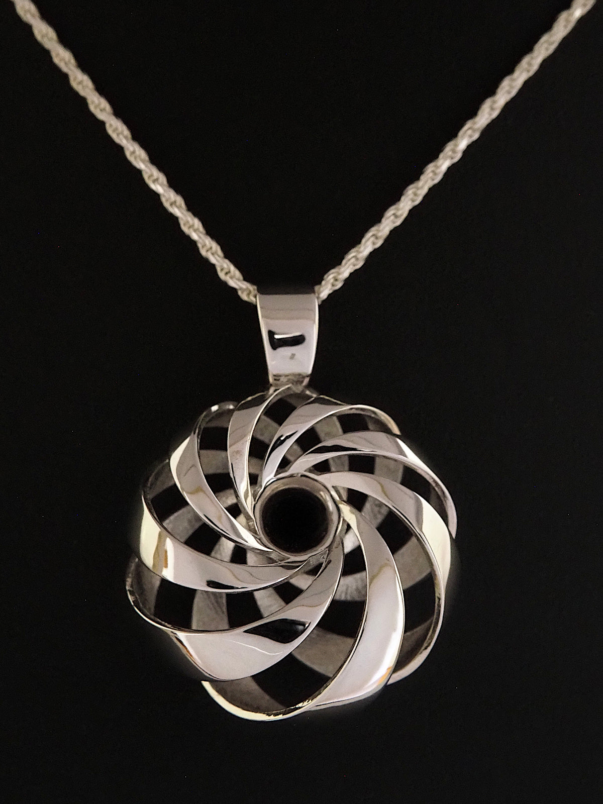 Close-up of a 25mm rhodium-plated brass cyclide pendant on a silver French rope chain.