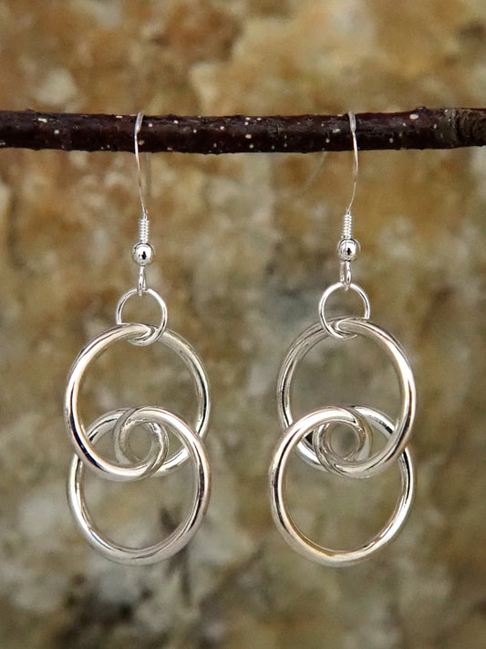 A pair of sterling silver trefoil knot earrings, front view.