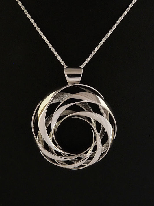 A 35mm rhodium-plated brass cyclide pendant on a silver French rope chain.